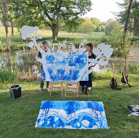 End of the concert: the blue painted backdrop is unfolded on the grass with the finished drawings