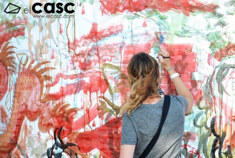 Close-up of a participant painting large red and green shapes