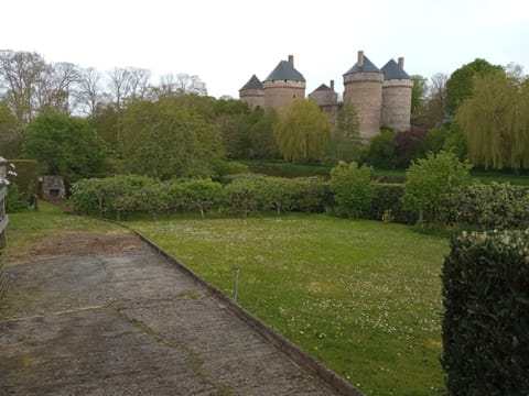 Pelouse et haies devant un château à tours rondes