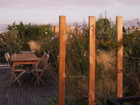Table en bois entre des poteaux et des graminées
