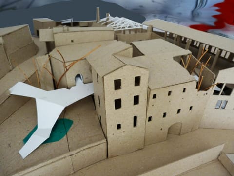 Maquette en carton d’un quartier, avec une forme blanche en papier plié
