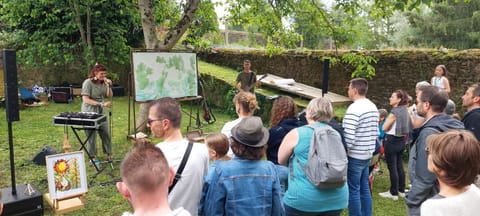 Silice open-air concert: the audience gathered in front of the duo, a large drawing on an easel behind