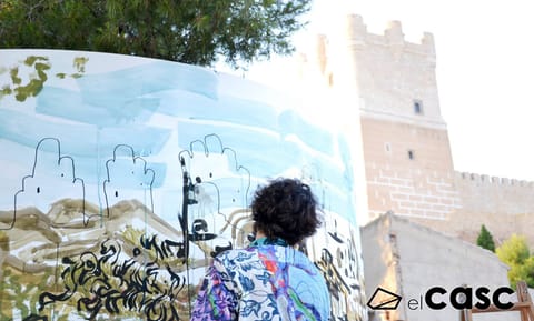 A participant paints on the ring facing a medieval tower
