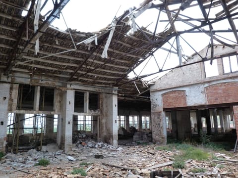 Vue depuis l’usine désaffectée, à travers de grandes ouvertures, sur les montagnes